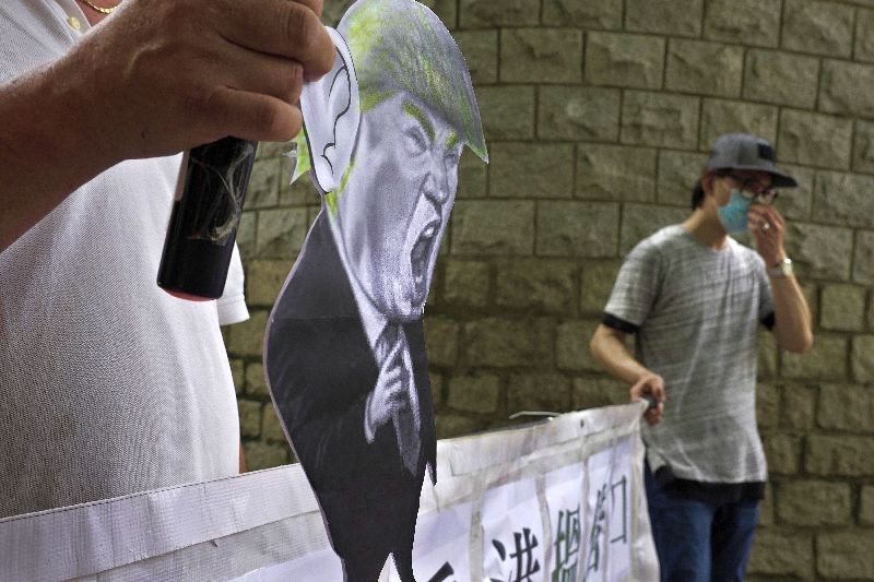 Pro-China supporters displays a picture of U.S. President Donald Trump during a protest against the U.S. sanctions outside the U.S. Consulate in Hong Kong . (Photo by Vincent Yu/AP Photo)